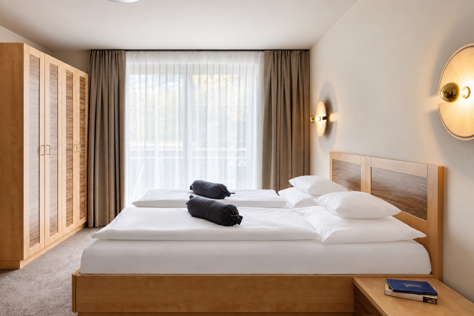 Schlafzimmer mit Doppelbett und hellen Gardinen